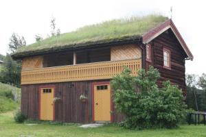 une maison avec un toit en gazon et deux portes dans l'établissement Romenstad Hytter, à Rendalen