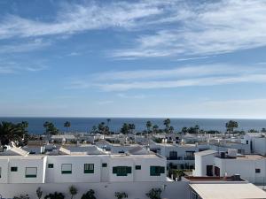 uitzicht op een stad met witte gebouwen en de oceaan bij Forever Views in Puerto del Carmen