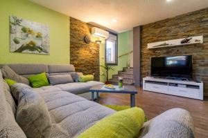 a living room with a couch and a flat screen tv at FERIENHAUS GRETA in Vodnjan
