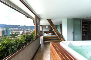 a bathroom with a tub and a view of the city at The Charlee Hotel in Medellín