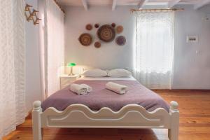 a bedroom with a white bed with towels on it at KasteliSuites in Chania Town