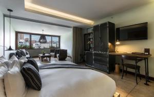 1 dormitorio con 1 cama blanca grande y escritorio en The Charlee Hotel, en Medellín
