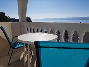 a table and chair on a balcony with a view of the ocean at Apartments Vlatko in Lokva Rogoznica