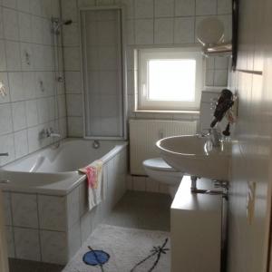 łazienka z umywalką, wanną i toaletą w obiekcie Ferienwohnungen am Schwanenteich w mieście Mühlhausen