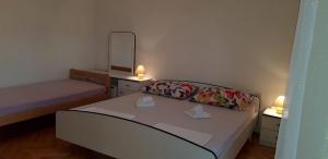 um pequeno quarto com 2 camas e um espelho em Apartment Ana Skale em Senj