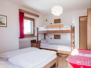 a bedroom with two bunk beds and a window at Rifugio Graziani Hütte in San Vigilio Di Marebbe