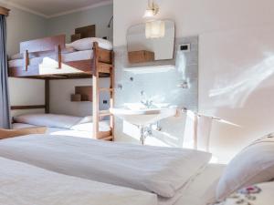 1 Schlafzimmer mit 2 Etagenbetten und einem Waschbecken in der Unterkunft Rifugio Graziani Hütte in St. Vigil