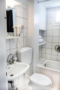 Baño blanco con aseo y lavamanos en Best located executive apartment in Maroussi., en Atenas