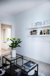 una sala de estar con una mesa de cristal con una planta. en Best located executive apartment in Maroussi., en Atenas