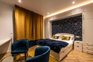 a bedroom with a king sized bed and two chairs at MM Suites Marlot in Reims