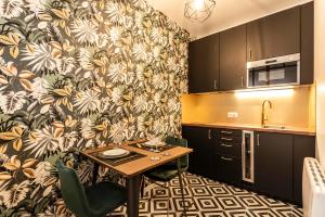 a small kitchen with a table in a kitchen at MM Suites Marlot in Reims +12 photos