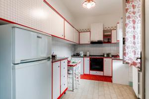 a kitchen with white appliances and red cabinets at Casa Aurora in Ravello +6 photos