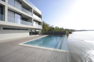 um edifício com uma piscina ao lado de um rio em Arade Riverside Modern Apartment em Estômbar