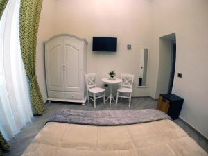 een slaapkamer met een bed en een tafel en stoelen bij B&B Le Stanze di Santa Chiara in Napels