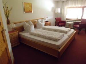 施盧赫湖的住宿－維森格倫德膳食公寓酒店，一间卧室设有两张床、一把椅子和一个窗户。