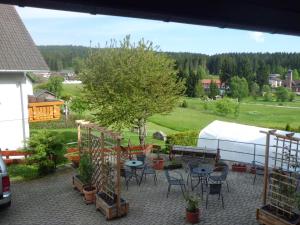 un patio con mesas y sillas y una tienda de campaña en Pension Wiesengrund, en Schluchsee