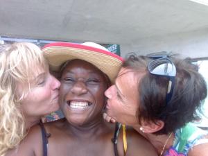 two women kissing a woman wearing a hat at The Pool House in Saint Philip