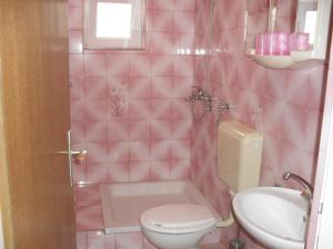 a pink bathroom with a toilet and a sink at Apartments in Lopar/Insel Rab 17728 in Lopar