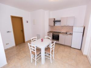 a kitchen with a white table and chairs in a room at Apartment in Njivice/Insel Krk 27659 in Njivice
