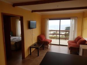 a room with a living room with a view of the ocean at Cabaña Vista Bahia Algarrobo in Algarrobo