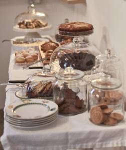 a table with plates and jars of cookies and cakes at Cas'E Charming House in Caserta