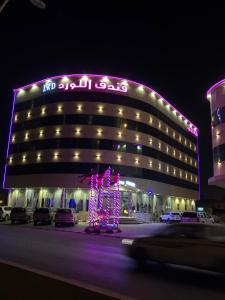 a large building with a lit up sign on it at Al Lord Hotel in Abū Qa‘ar