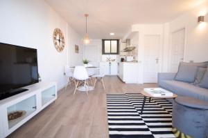 a living room with a blue couch and a tv at Tabaiba Premier Views Apartment in Tabaiba