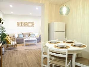 a kitchen and living room with a table and a refrigerator at Pé N'Areia - Beach Apartment with Terrace in Viana do Castelo