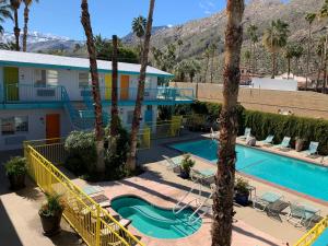 a resort with a swimming pool and palm trees at Adara Palm Springs in Palm Springs