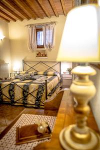 een slaapkamer met een bed en een tafel met een lamp bij Casa Al Bosco in SantʼEllero