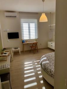una habitación con una cama, un escritorio y un televisor en Casa Francesco, en Bolsena