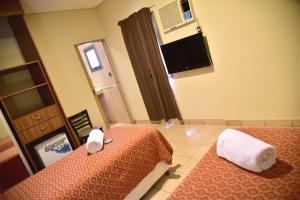 a hotel room with two beds and a television at Hotel Confianza in Corrientes