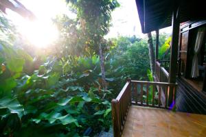 une terrasse couverte d'une maison avec des plantes vertes luxuriantes dans l'établissement Umah Tis Sebatu, à Tegalalang