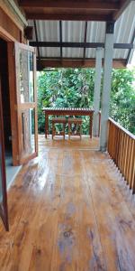 a wooden porch with a picnic table on it at Eco Breeze - Unawatuna in Galle