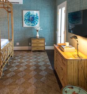 a bedroom with a bed and a dresser with a desk at Eleven Bahama House in Harbour Island