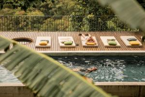 a group of people laying on beds next to a pond at Chez Georges in Rio de Janeiro