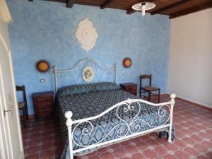 a bedroom with a bed with a blue wall at Agriturismo Pinturicchio in Capo Vaticano