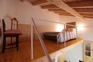 una camera da letto con un letto e una sedia in una stanza di Casa das Minas a Minas de São Domingos
