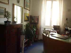 リヴォルノにあるAlbergo Cavour SELF CHECK-INのデスクとパソコンが備わるオフィス