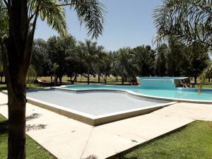 uma piscina num parque com uma palmeira em CATANGE HOTEL em Charata