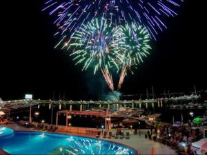un fuochi d'artificio sopra una piscina di fronte a una barca di Apartment Complex “TOP” a Sveti Vlas