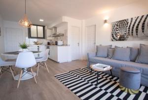 a living room with a blue couch and a kitchen at Tabaiba Premier Views Apartment in Tabaiba