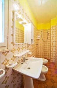 y baño con 2 aseos, lavamanos y espejo. en Holiday home in Bibione 24575 en Bibione