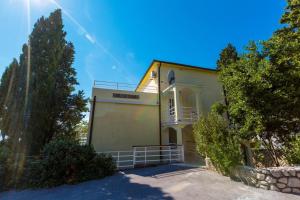 a large house with trees in front of it at Apartment in Crikvenica 14104 in Sopaljska