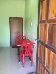 una mesa roja y sillas en una habitación con puerta en Santai Lots Cherating, en Kuantan