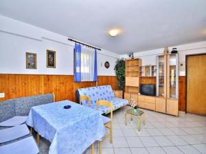 a living room with a table and chairs and a tv at Apartment Pula, Istria 18 in Veli Vrh