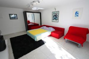 a living room with a bed and a red couch at Crikvenica Apartment 24 in Dramalj