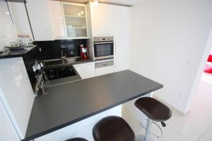 a kitchen with white cabinets and a black counter top at Crikvenica Apartment 24 in Dramalj
