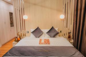 una camera da letto con un letto grande con due cuscini di Silent Night Dem Lanh Hotel a Da Lat Altre 191 foto