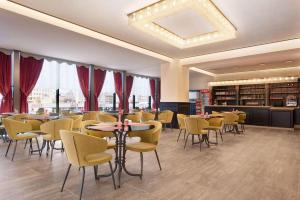 un restaurante con mesas y sillas en una habitación en Ramada by Wyndham Sivas en Sivas